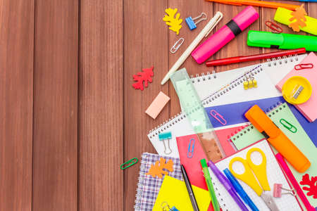 Back to school concept. School education supplies on brown wooden boards background, flat lay, copy space, top viewの写真素材