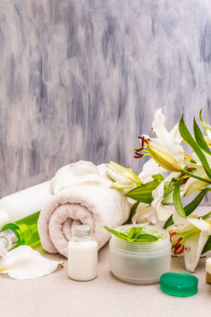 Healthy and beauty spa flower concept. Natural ingredients for relaxation. Mint salt, olive soap, green tea essential oil, towels, shower gel. Stone concrete, abstract background, copy spaceの写真素材