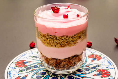 Delicate cream dessert. Traditional turkish edible rose, flower petals. Painted ceramics with a...
