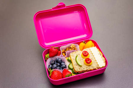 School lunch box with sandwich, fresh fruits, vegetables and nuts. Healthy eating habits for kids....
