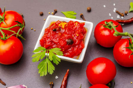 Tomato confiture, jam, chutney, sauce in ceramic bowl. Homemade preservation concept. Fresh...