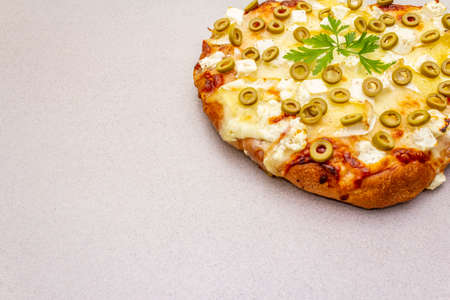 Italian focaccia with three types of cheese, green olives and parsley. Traditional food concept on stone background, copy spaceの写真素材