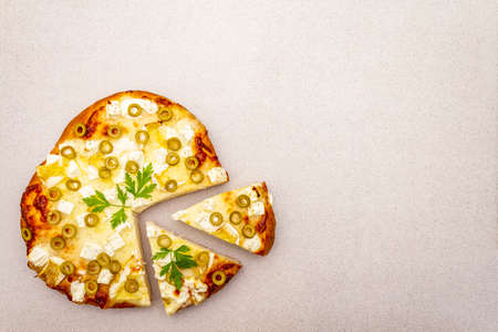 Italian focaccia with three types of cheese, green olives and parsley. Traditional food concept, cut...