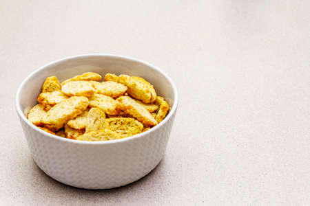 Fresh croutons for hot autumn cream soups. Traditional fast crisp snack. In ceramic bowl on a stone...