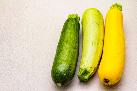 Assorted colorful zucchini. Fresh vegetables for cooking. Harvest on stone background, copy spaceの写真素材