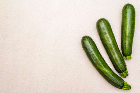 Bright green zucchini. Fresh vegetables for cooking. Harvest on stone background, top view, copy space, isolatedの写真素材