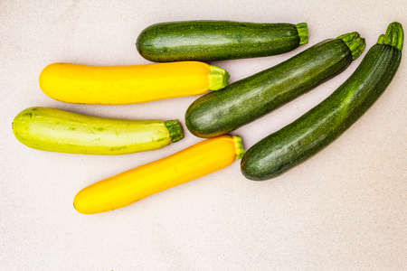 Assorted colorful zucchini. Fresh vegetables for cooking. Harvest on stone background, copy space, top viewの写真素材