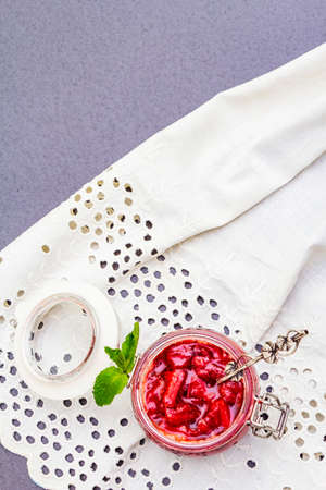 Strawberry jam in a glass jar. Homemade preservation concept. With fresh strawberries and mint,...