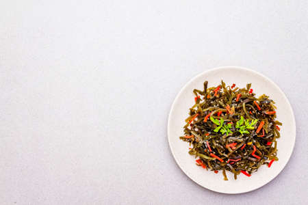 Laminaria salad (Kelp) with red ginger and sesame seeds. Seafood rich in iodine and minerals. Healthy eating concept. Cooking food stone background, copy space, top viewの写真素材