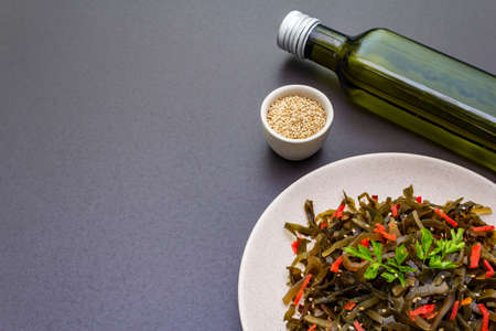 Laminaria salad (Kelp) with red ginger and sesame seeds. Seafood rich in iodine and minerals. Healthy eating concept. Cooking food stone background, copy spaceの写真素材
