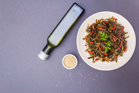 Laminaria salad (Kelp) with red ginger and sesame seeds. Seafood rich in iodine and minerals. Healthy eating concept. Cooking food stone background, top view, copy spaceの写真素材
