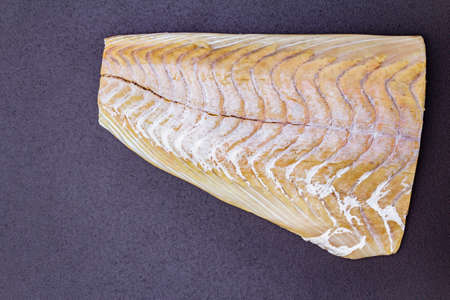 Fresh pollock fillet. Concept of healthy seafood. Organic fish on a black stone background, top view