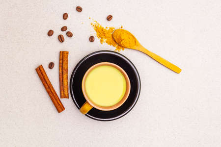 Golden turmeric cinnamon coffee latte. Trendy healthy hot drink concept. In ceramic cups on stone background, copy space, top viewの写真素材
