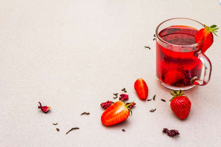 Summer strawberry hibiscus green tea. Healthy hot organic drink served in glass cups. Fruits cooking stone background, copy spaceの写真素材