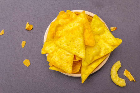 Assorted salty spiced snacks. Rings, nachos. In ceramic bowls on a stone background, top view, close upの写真素材