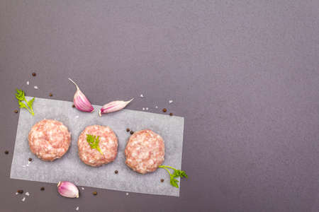 Raw fresh pork cutlets with spices and vegetables Healthy eating concept, animal proteins and vitamin. On a stone background, top view, copy spaceの写真素材