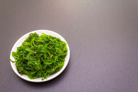 Traditional Japanese Hiyashi Wakame Chuka seaweed salad with sesame seeds. Healthy food concept...