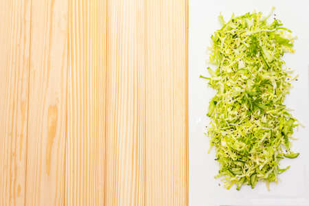 Fresh cabbage salad. Healthy vegan (vegetarian) food concept. Organic vegetables and sesame seeds, ceramic plate. On wooden background, top view, flat lay, copy spaceの写真素材