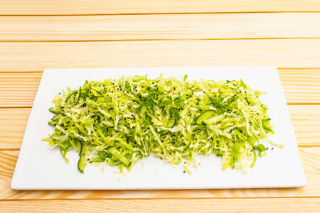 Fresh cabbage salad. Healthy vegan (vegetarian) food concept. Organic vegetables and sesame seeds, ceramic plate. On wooden background, copy spaceの写真素材