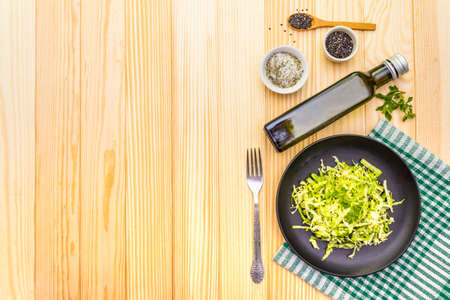 Fresh cabbage salad. Healthy vegan (vegetarian) food concept. Organic vegetables and sesame seeds, olive oil, sea salt. On wooden background, copy space, top viewの写真素材
