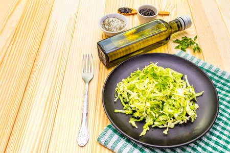 Fresh cabbage salad. Healthy vegan (vegetarian) food concept. Organic vegetables and sesame seeds, olive oil, sea salt. On wooden background, copy space, close upの写真素材
