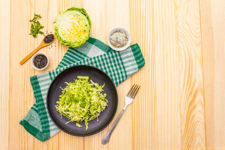 Fresh cabbage salad. Healthy vegan (vegetarian) food concept. Organic vegetables and sesame seeds, olive oil, sea salt. On wooden background, copy space, top viewの写真素材