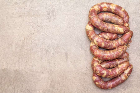 Raw pork sausage. Ingredient for cooking on the grill, picnic and homemade or restaurant food. On a stone background, copy space, top viewの写真素材