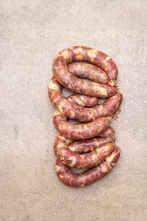 Raw pork sausage. Ingredient for cooking on the grill, picnic and homemade or restaurant food. On a stone background, copy space, top viewの写真素材