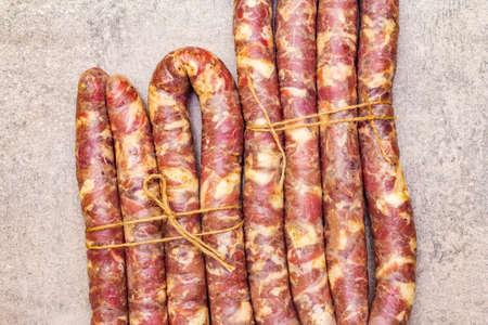 Raw pork sausage. Ingredient for cooking on the grill, picnic and homemade or restaurant food. On a stone background, top view, close upの写真素材