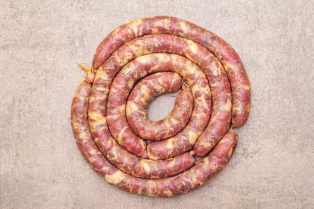 Raw pork sausage. Ingredient for cooking on the grill, picnic and homemade or restaurant food. On a stone background, close up, top viewの写真素材