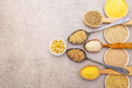 Healthy food vegetarian (vegan) concept. Assorted various organic cereals, legumes, whole grains. In ceramic bowls and wooden spoons on a stone background, copy space, top viewの写真素材