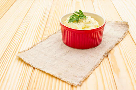 Warm mashed potatoes in a ceramic bowl with fresh parsley. On a vintage linen napkin on a wooden background, copy spaceの写真素材
