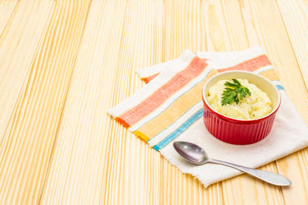 Warm mashed potatoes in a ceramic bowl with fresh parsley. On a vintage linen napkin on a wooden background, copy spaceの写真素材