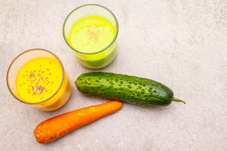 Organic cucumber and carrot smoothies with sesame and chia seeds. Healthy diet concept. On a stone background, copy space, top viewの写真素材