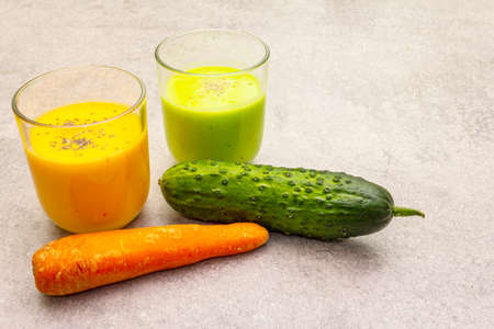 Organic cucumber and carrot smoothies with sesame and chia seeds. Healthy diet concept. On a stone background, copy spaceの写真素材
