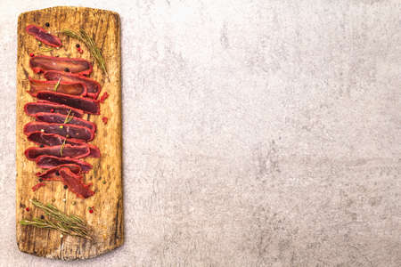 Basturma, dried tenderloin of beef meat, jerky, thinly sliced. Dry rosemary, pepper mix on vintage...