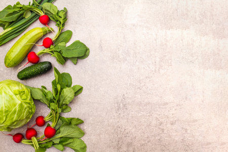 Assortment fresh green organic vegetables. Food cooking stone background. Healthy vegetarian (vegan) eating concept, top view, copy space, flat layの写真素材