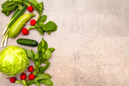 Assortment fresh green organic vegetables. Food cooking stone background. Healthy vegetarian (vegan) eating concept, top view, copy space, flat layの写真素材
