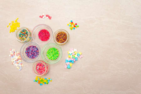Assortment of various Easter decorative sugar sprinkles, Food background. In glass bowls on stone...