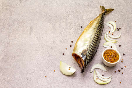 Whole smoked mackerel carcass. Dijon mustard, onion, black pepper, coriander. On a stone background, copy spaceの写真素材