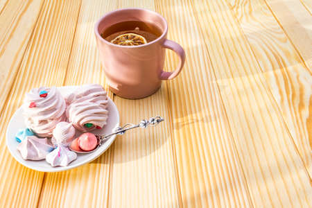 Romantic sweet breakfast concept. Green tea, lemon, meringue (cake). On wooden backgroundの写真素材