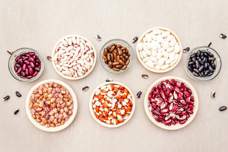 Assortment of beans on a stone background. Crimson cranberry, red, painted pony, black turtle,...