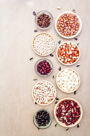 Assortment of beans on a stone background. Crimson cranberry, red, painted pony, black turtle,...