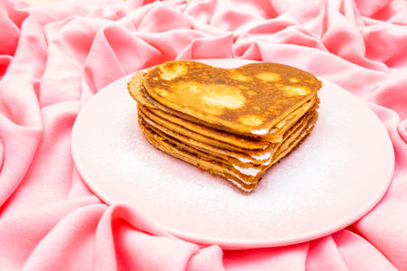 Heart shaped pancakes for romantic breakfast on rosy plate.の写真素材
