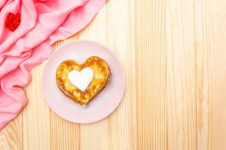 Heart shaped pancakes for romantic breakfast. Shrovetide (carnival) concept. On wooden background...