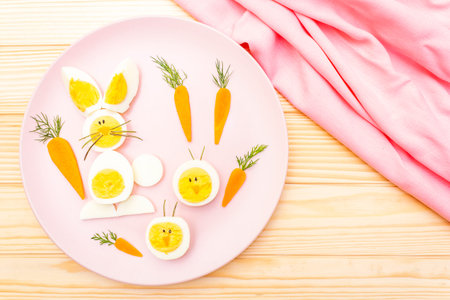 Easter bunny (rabbit) and chicken eggs children (kids) food concept. With carrot on rosy (pink)...