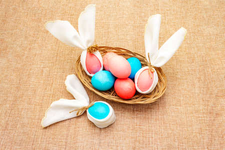 Easter bunny (rabbit) egg concept, table arrangement decoration. Pink (rosy) and blue eggs with...