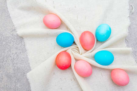 Easter concept pink (rosy) and blue eggs on vintage cloth (linen) napkin. Stone background, top...