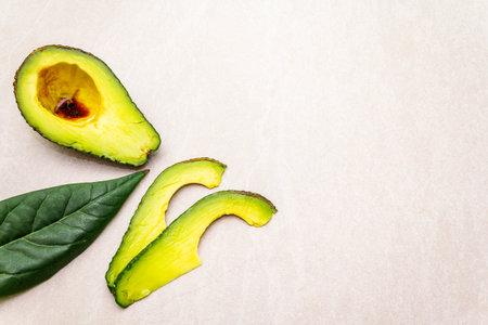 Avocado, cut in half, avocado slices, and avocado leaf with soy sauce. Cooking background. On the...