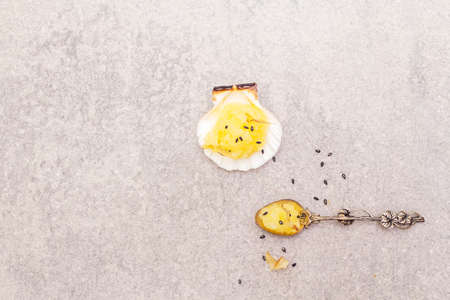 Capelin roe in seashells. Black sesame seeds with bonito flakes. Lightly salted caviar snack in silver spoon on a stone background, top view.の写真素材